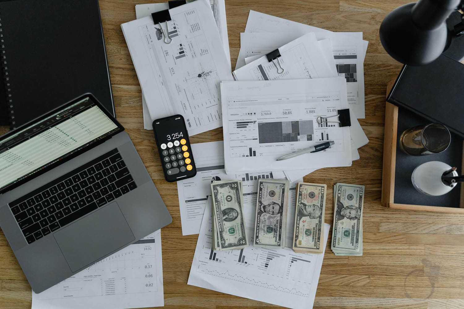 pexels-tima-miroshnichenko-6693655_1500 A desktop with accounting items: laptop, calculator, dollar bills, receipts, etc.